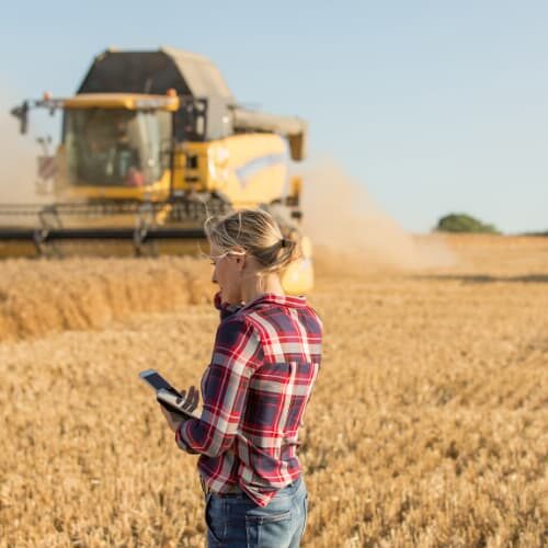 Woman in field with a combine